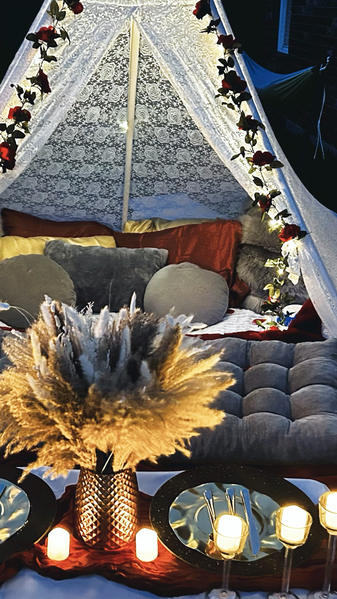 Real Enchanting Escapes canopy setup with roses, floor cushions and LED candles